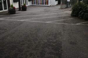 Worn car park bay markings before line marking