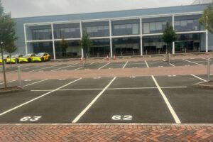 Numbered white parking bays marked in front of an office block