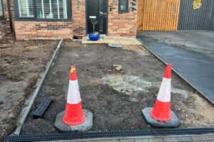 Front driveway prepared for tarmac resurfacing with traffic cones