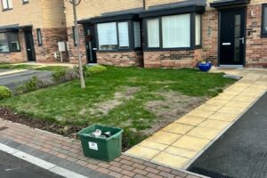 Front garden and paved path beside a new tarmac driveway